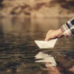 紙の船を川に浮かべている